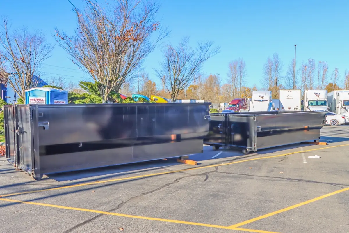 Professional dumpster rental service with roll-off container on residential driveway in Frankford